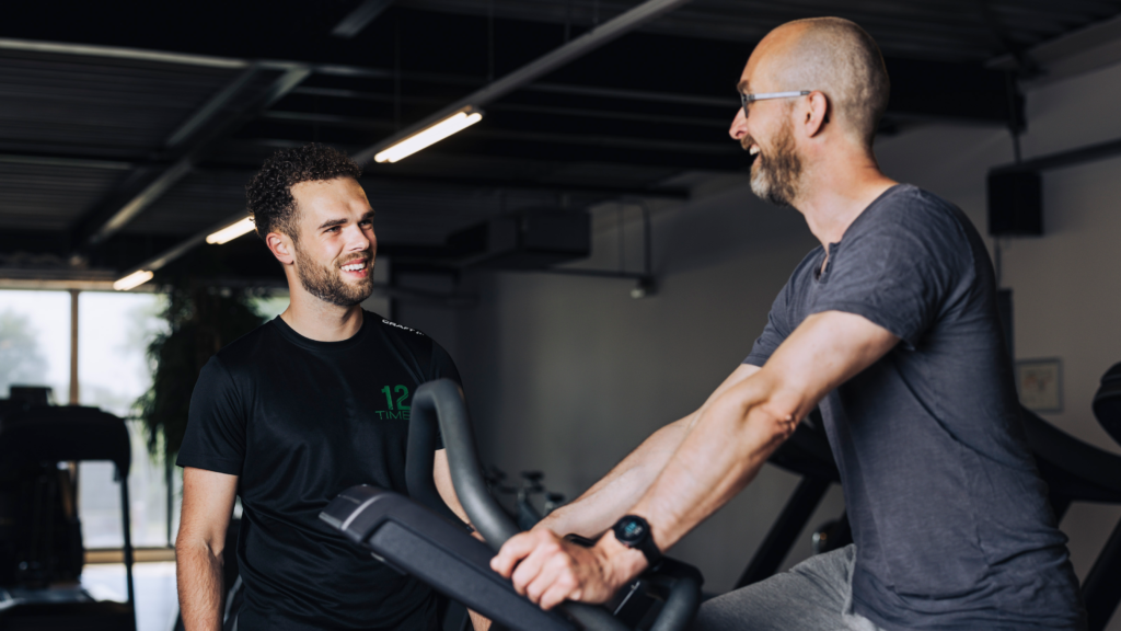 Personal trainer van 12TIMES begeleidt klant tijdens cardiotraining in Zwolle